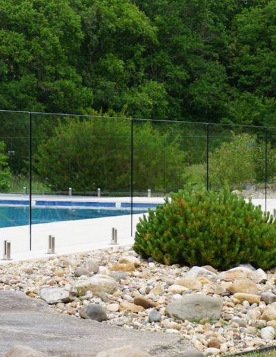 Architectural glass pool barrier in organic surroundings