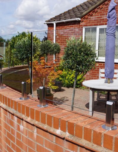 Wall mounted glass fence for wind protection