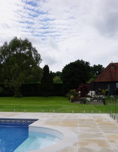 Unobtrusive frameless glass swimming pool safety fence
