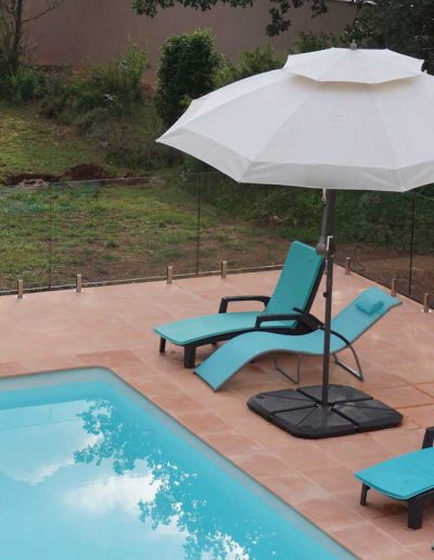 Terracotta, aqua and frameless glass pool barrier