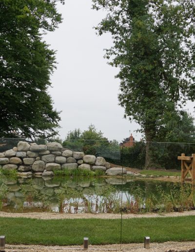 Frameless glass fence in concrete footing